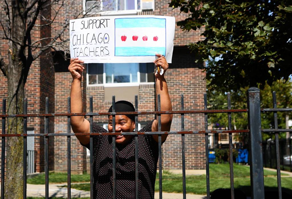 Neighbors cheer on Chicago Teachers Union members as they rally near Marshall High School on the West Side of Chicago.