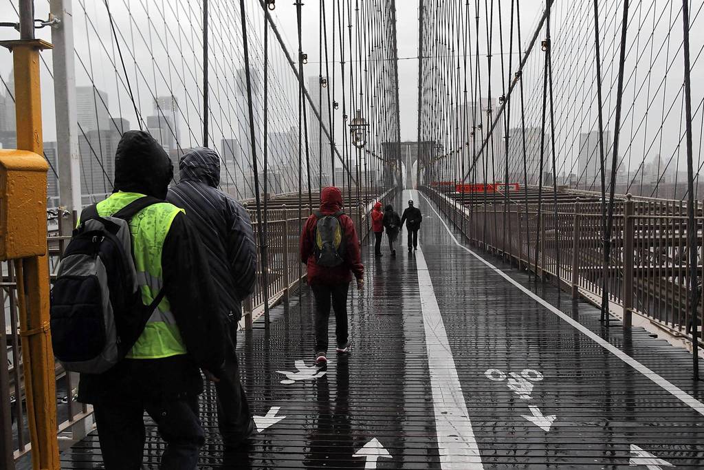 People walk across the Brooklyn Bridge as Hurricane Sandy begins to affect New York City. The storm, which threatens 50 million people in the eastern third of the U.S., is expected to bring days of rain, high winds and possibly heavy snow. New York Governor Andrew Cuomo announced the closure of all New York City will bus, subway and commuter rail service as of Sunday evening.