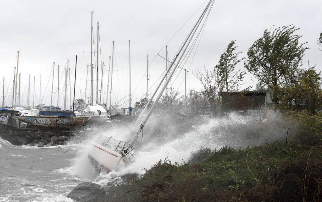 A sailboat smashes on the rocks after breaking free from its mooring on City Island in New York. Hurricane Sandy's winds picked up speed as the storm made a left turn toward the East Coast.