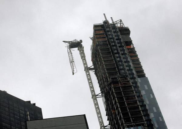 A crane hangs from a building after being damaged in winds from Hurricane Sandy in New York.