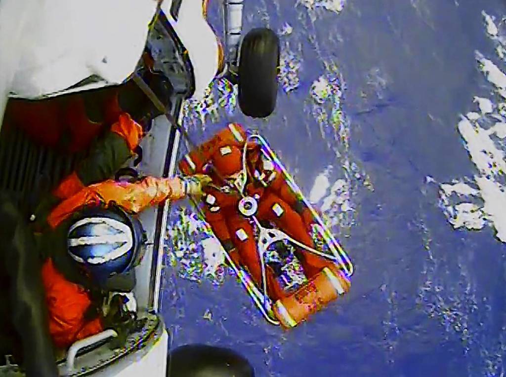 A frame from a video shows a crew member of the HMS Bounty being lifted to a Coast Guard rescue helicopter in a rescue basket, 90 miles southeast of Cape Hatteras, North Carolina. The Coast Guard rescued 14 people from life rafts after the ship went down in the rough seas of Hurricane Sandy.