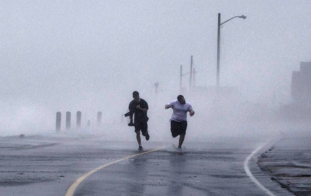 Two boys run down Foster Avenue while dodging high winds and waves from the effects of Hurricane Sandy in Marshfield, Massachusetts. The monster storm bearing down on the East Coast, strengthened on Monday after hundreds of thousands moved to higher ground.