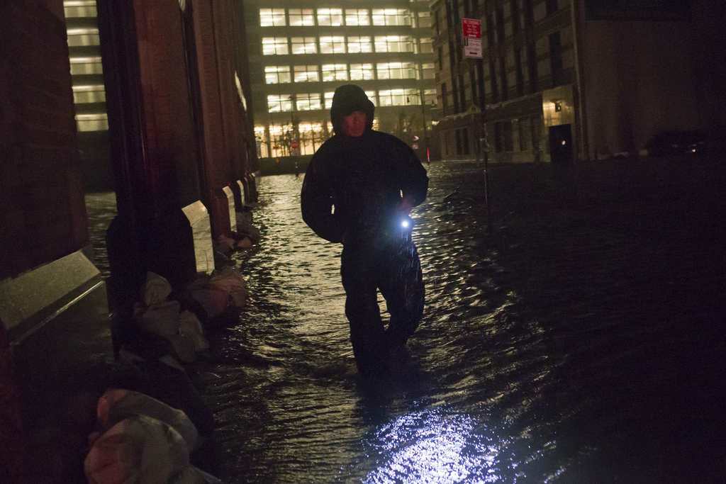 A security guard walks through a flooded street in the financial district of Manhattan, New York. NYSE Euronext said it is preparing to implement a new contingency plan to help resume stalled U.S. equity trading, and added that its famed trading floor is not yet damaged by Hurricane Sandy.