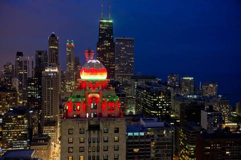 The dome of the InterContinental Hotel and the skyline of Chicago, including the Hancock Center, background, are lit for the holidays.