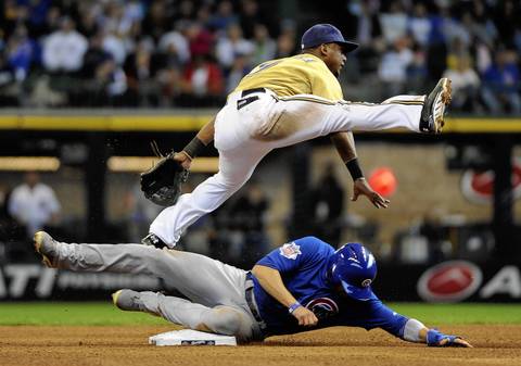 Brewers shortstop Jean Segura jumps over David DeJesus to complete a double play in the fifth inning.
