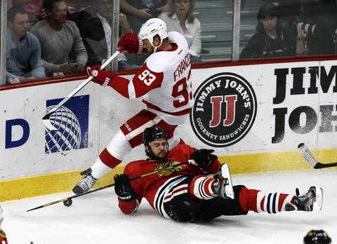 Brent Seabrook gets the worse of a battle for the puck against the Red Wings' Johan Franzen during the first period.