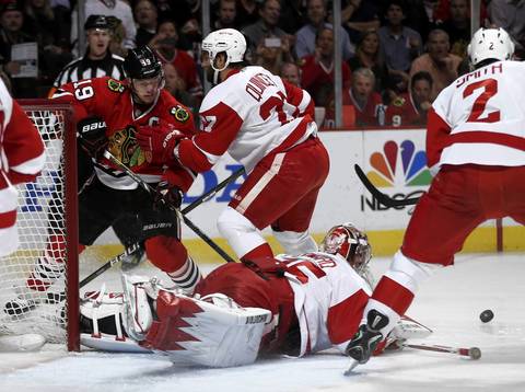 Red Wings goalie Jimmy Howard makes a save in front of Jonathan Toews in the first period.
