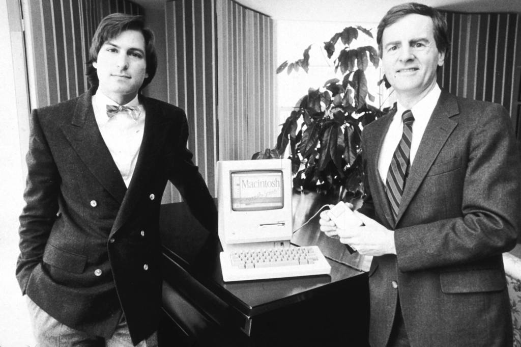 American businessman Steve Jobs (L), Chairman of Apple Computers, and John Sculley, Apple's president, pose with the new Macintosh personal computer in New York City.