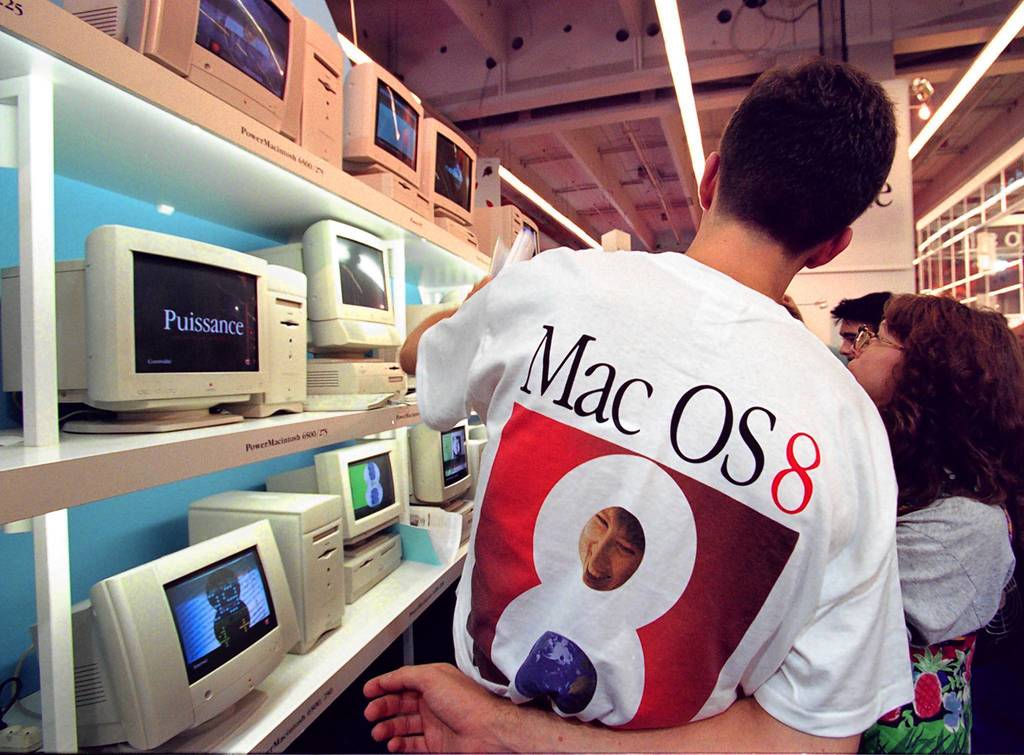 A salesman for Apple Computer shows a potential customer new models during the Apple Expo show at the Porte de Versailles exhibition site in Paris.
