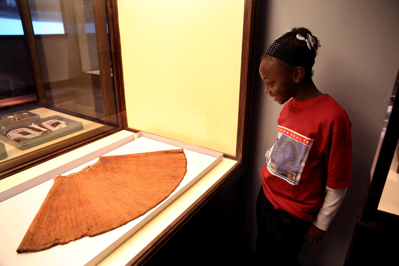Jamaica Wright, 9, from Leif Ericson Elementary Scholastic Academy checks out a skirt made from pine needles.