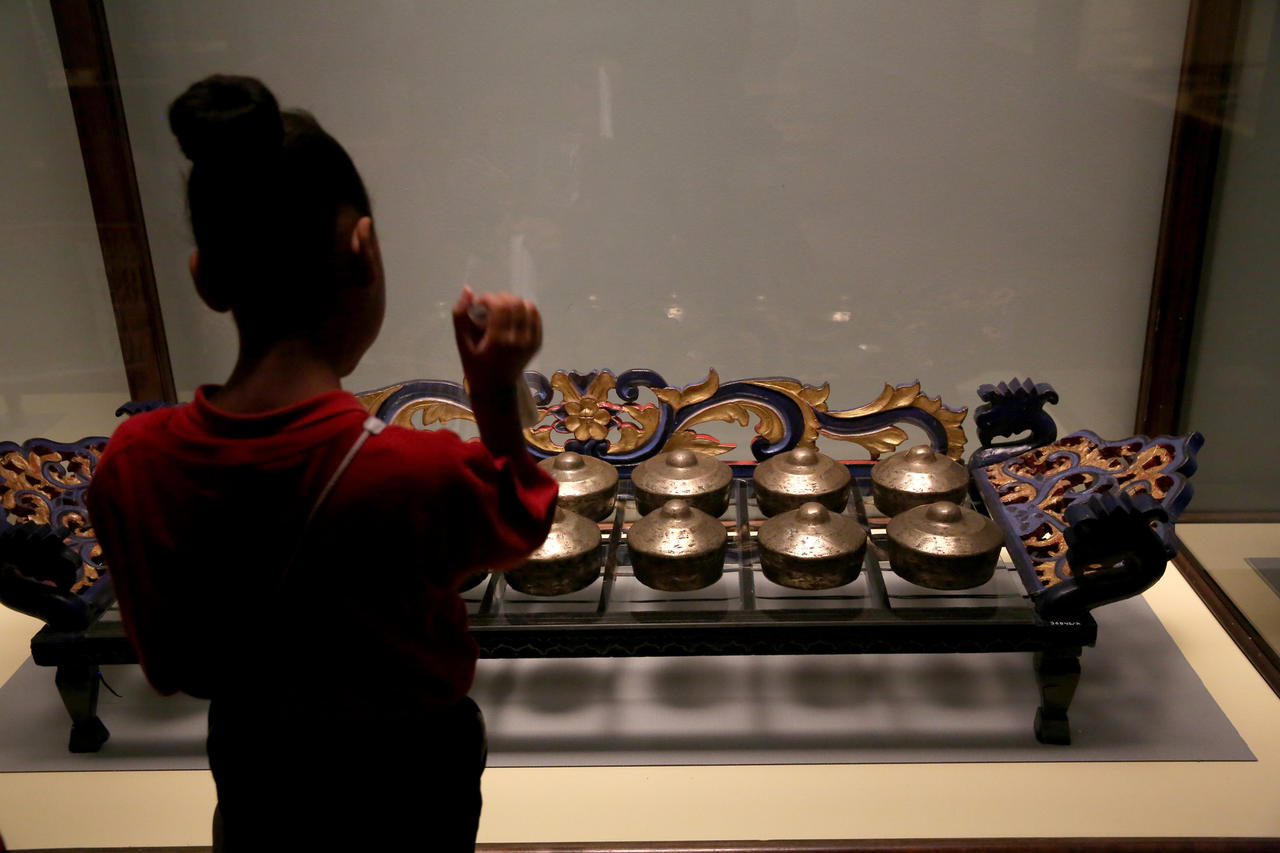 A student from Leif Ericson Elementary Scholastic Academy looks at part of a gamelon set from Indonesia on display.