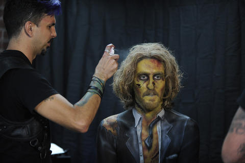 Nicholas "Nix" Herrera sprays the zombie groom's hair.