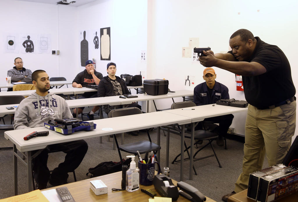 Instructor Andre Queen works with students on proper technique for holding their gun during a training course in 2013 for people planning to apply for a conceal carry permit.