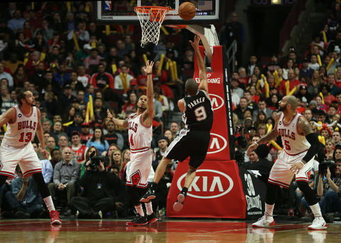 The Spurs' Tony Parker scores on D.J. Augustin in the first half.