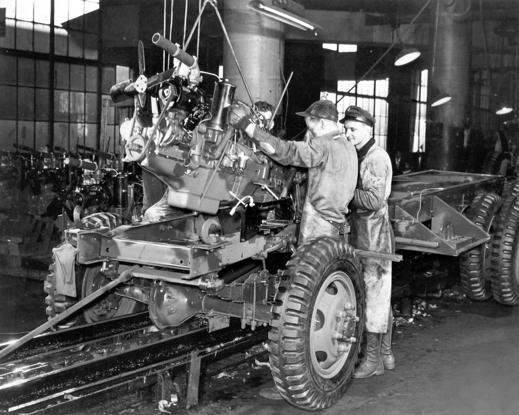 Workmen mount an engine to an Army truck near the end of the assembly line at The Studebaker Corporation in February 1942.