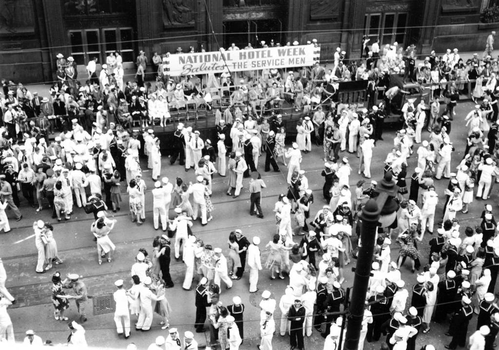 Soldiers and sailors from the Service Men's Center dance with women on LaSalle Street, between Washington and Randolph Streets, in Chicago.