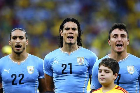 Martin Caceres, left, Edinson Cavani, center, and Cristian Rodriguez of Uruguay sing the National Anthem before the 2014 FIFA World Cup Brazil round of 16 match between Colombia and Uruguay at Maracana.