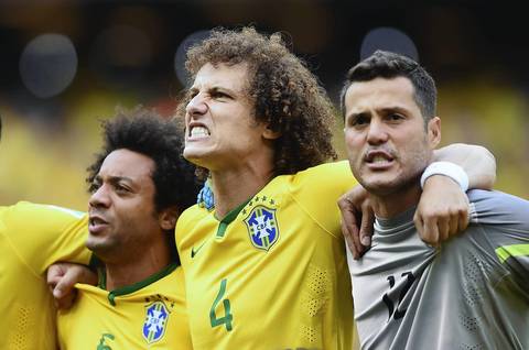 Marcelo, left, David Luiz, center, and Julio Cesar of Brazil sing the National Anthem with before the 2014 FIFA World Cup Brazil Group A match between Brazil and Mexico at Castelao in Fortaleza, Brazil.