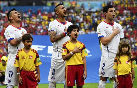 Gary Medel, left, Arturo Vidal, center, and Eugenio Mena of Chile sing the National Anthem before the 2014 FIFA World Cup Brazil Group B match between Spain and Chile in Rio de Janeiro