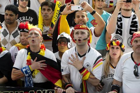 German soccer fans sing their national anthem at the 'Fan Mile' where the 2014 World Cup group G soccer match between Germany and Portugal is screened in Berlin.