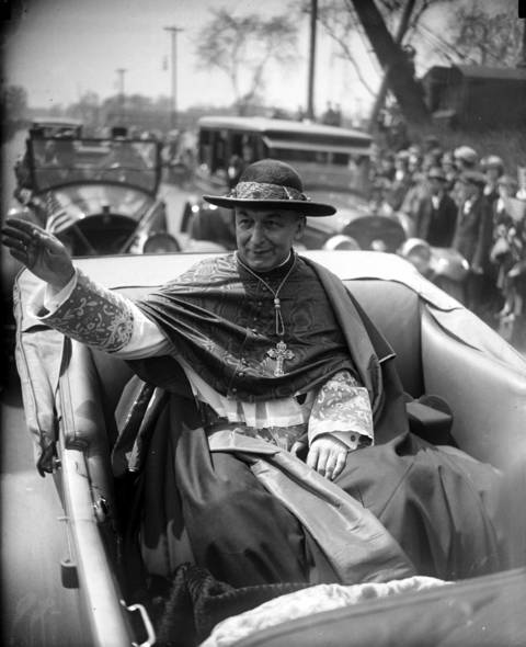 Cardinal Mundelein raises his right hand to bestow his blessings upon the crowd on May 11, 1924, during a parade in his honor following his return home from Rome after being appointed Cardinal. According to the Tribune, "people lined the course of the Cardinal from his train to his church solidly for fifteen miles."