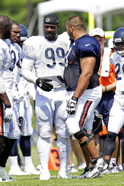 Bears defensive end Lamarr Houston chats with center Roberto Garza.