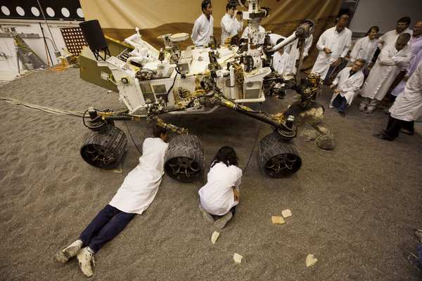At Jet Propulsion Laboratory, Joseph Carsten, left, and Vandi Tompkin watch from beneath the rover model during testing for the Curiosity mission on Mars.