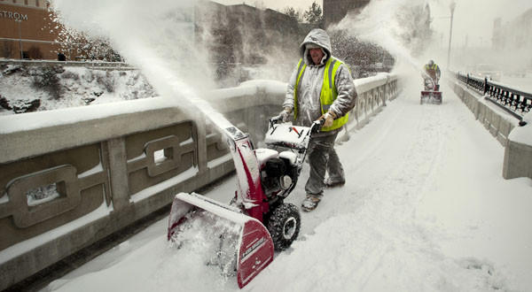 Tristan Long and Hayden Symbol with the City of Spokane Water Department remove snow from the Monroe Street Bridge in Spokane, Wash. Heavy snows, high winds, tornadoes and flooding were seen across the U.S. during Thanksgiving week 2010, disrupting travel and holiday plans.