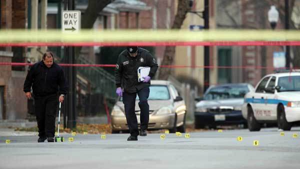 Chicago police investigate the scene where officers shot and killed a man near the corner of Coles and 79th Street. 