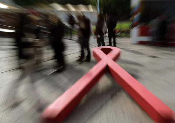 People gets information about AIDS near a giant red ribbon, symbolizing AIDS awareness, in the center of Athens during World AIDS Day on December 1, 2008. 