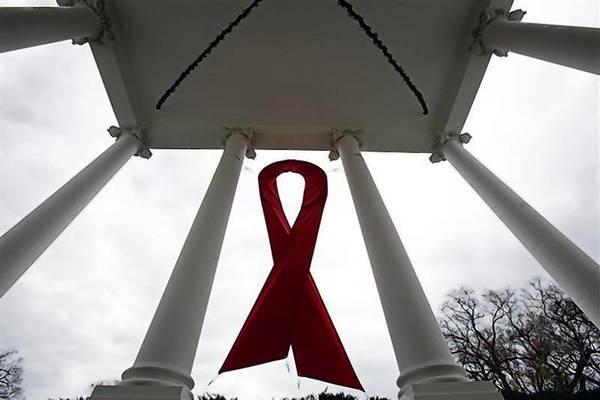 An AIDS ribbon hangs from the North Portico of the White House in Washington in recognition for tomorrow's World AIDS Day