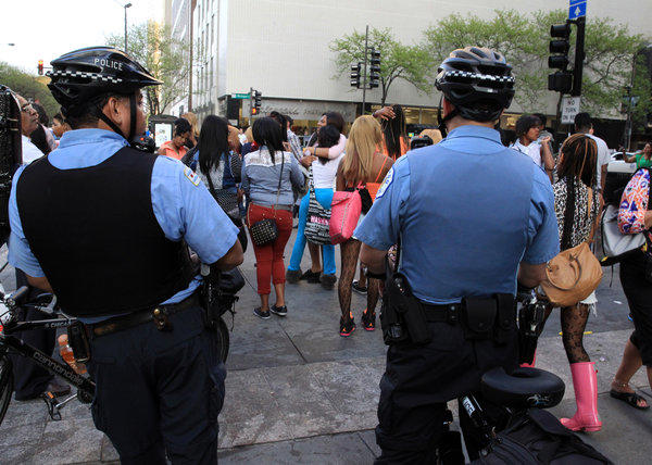 Chicago police officers monitor a group of teens near the intersection of Chicago and Michigan Ave., in the Gold Coast neighborhood on Saturday May 18, 2013.