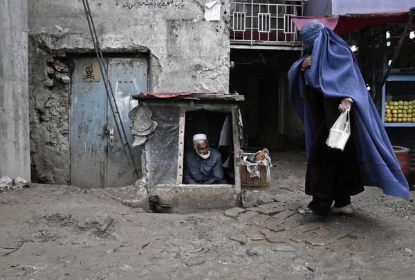 Afghan woman makes her way on the outskirts of Kabul