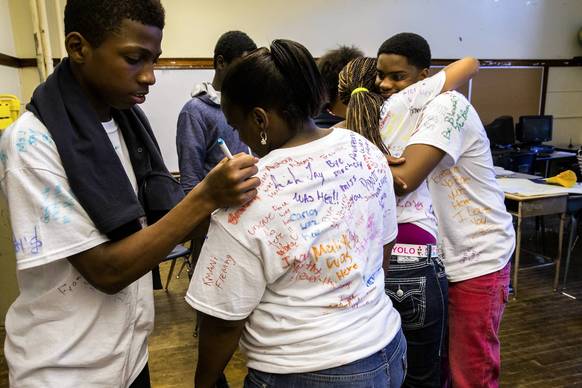 Seventh grade students hug and sign shirts just before dismissal on the last day of school at West Pullman Elementary. The CPS is closing this school and relocating the students to existing schools in the neighborhood.
