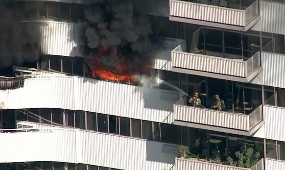 A fire burns on the 11th floor of the Barrington Plaza apartments. L.A. fire officials said the building, in the 11700 block of Wilshire Boulevard, is not equipped with a sprinkler system because it was built 52 years ago and does not fall under state regulations adopted in 1974 that require buildings taller than 75 feet to include such fire-suppression systems.