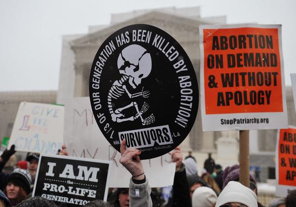 Antiabortion and pro-choice placards are seen in front of the Supreme Court. 
