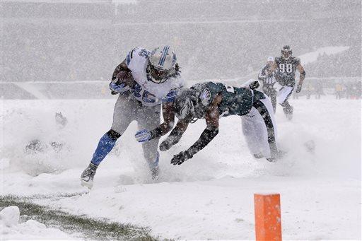 The Detroit Lions' Joique Bell, left, is tackled by Philadelphia Eagles' Bradley Fletcher during the first half of a snowy NFL football game in Philadelphia.