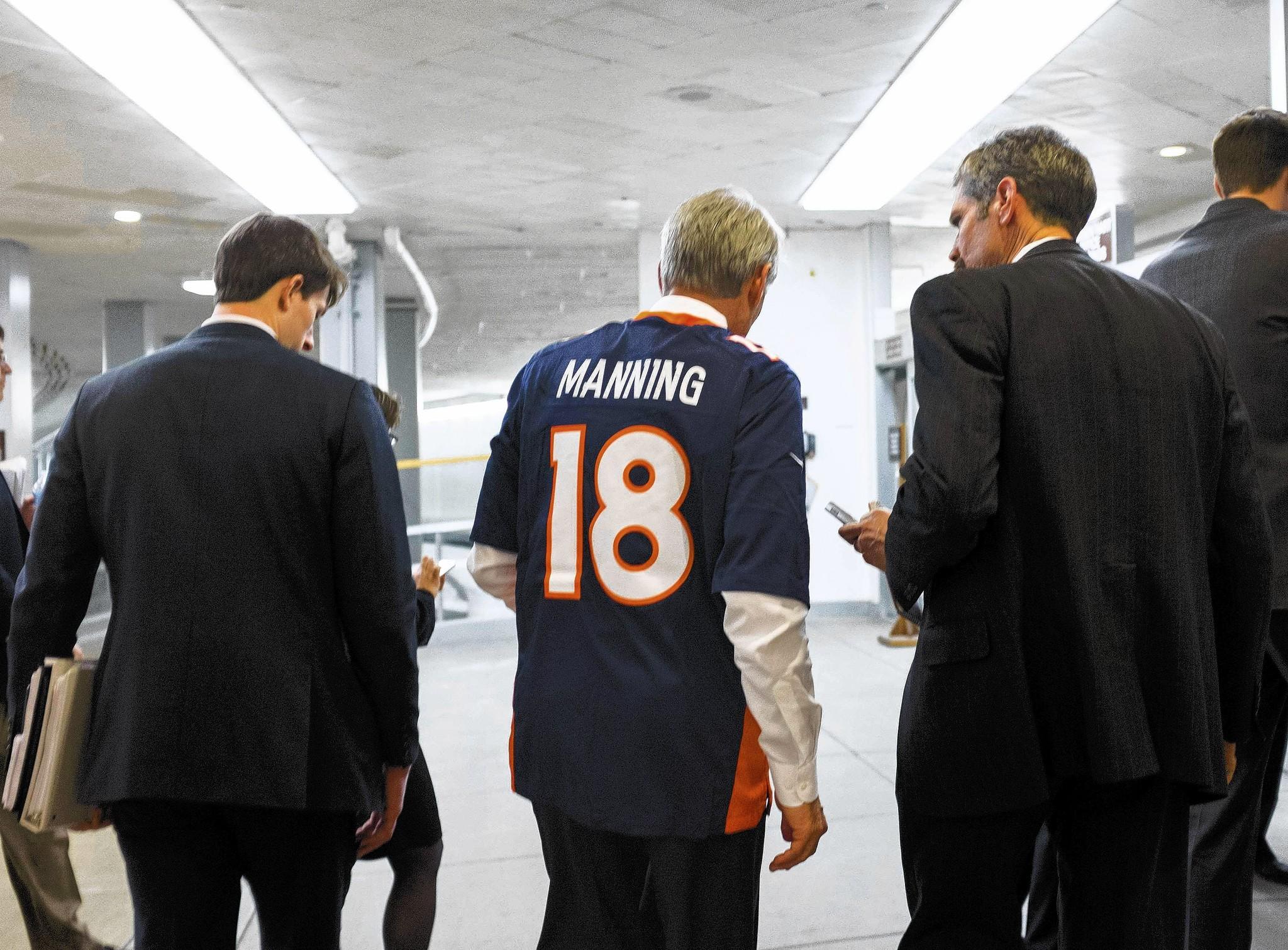 Sen. Mark Udall, D-Colo., wears a football jersey from the Denver Broncos, the team liberals should root for Sunday during the Super Bowl.