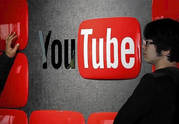 Visitors stand in front of a logo of YouTube at the YouTube Space Tokyo, operated by Google, in Tokyo