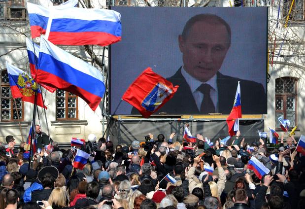 People wave flags as they watch Russian President Vladimir Putin    freelance one word or two