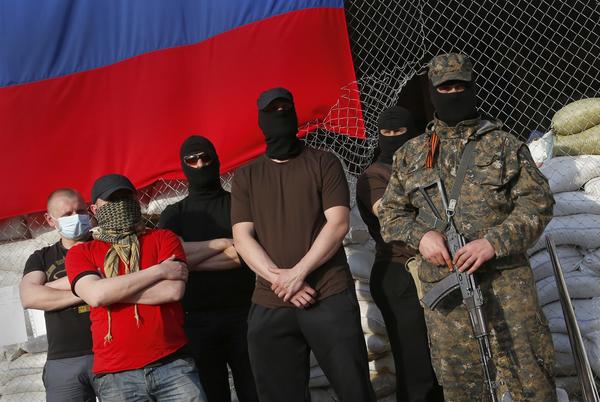 Masked and armed pro-Russia activists stand at the city hall in the Ukrainian city of Slovyansk during negotiations for the release of European military observers being held in eastern Ukraine. The European Union has imposed sanctions on Russia for its role in the rebellion in neighboring Ukraine.