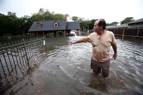 Kevin Davis tries to pump water out of his flooded home in Pensacola, Florida, on April 30.