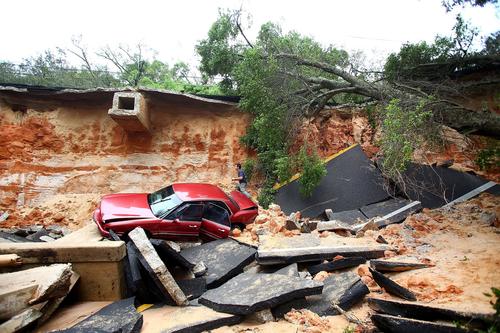 People survey the damage on Scenic Highway after part of the highway collapsed following heavy rains and flash flooding on April 30, 2014 in Pensacola, Florida.