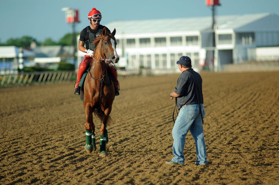 Exercise rider Willie Delgado and Kentucky Derby champ California Chrome walk toward assistant trainer Alan Sherman after a workout Tuesday morning at Pimico Race Course.