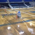 Pauley Pavilion: Workers use squeegees on flood waters at UCLA