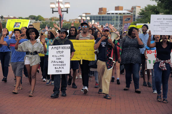 Marchers walk up from the Maryland Science Center toward Harborplace during a protest that started outside Baltimore City Hall.