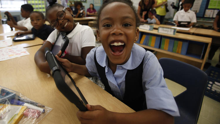 Tiannah Dizadare smiles as she and a school mate explore the possibilities with their new LAUSD provided IPads.