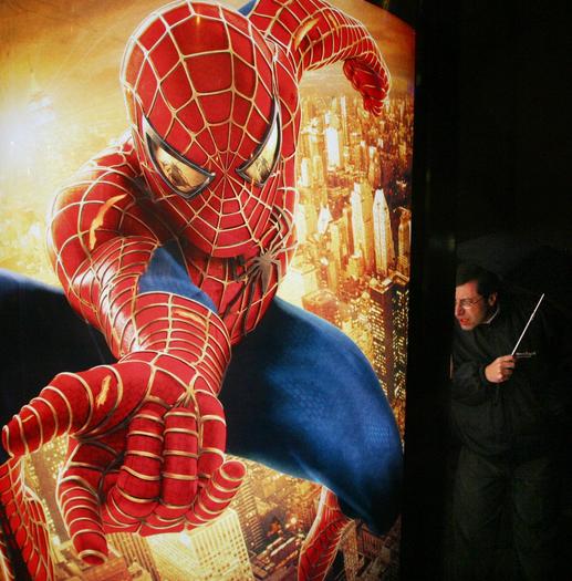2004 photo, a man looks at an advertisement for the "Spider-Man" movie ...