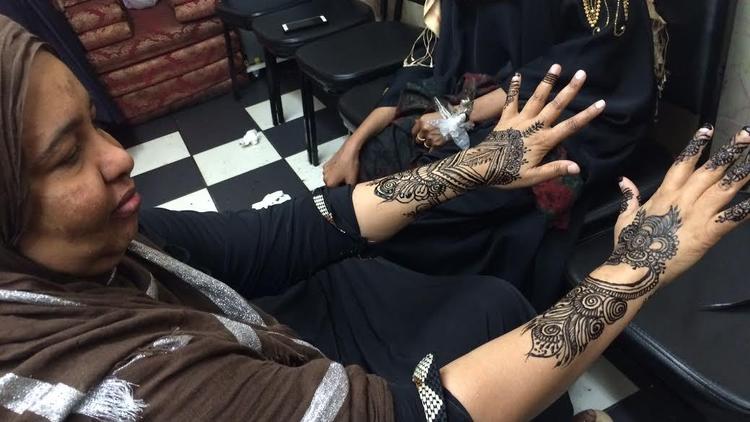 A woman gets henna artwork on her hands in the Karmel Square mall.