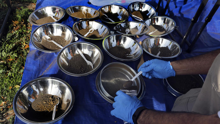 An environmental health specialist for the L.A. County Health Dept. places a soil sample collected from the front and back yard of a home on Ransom St. in Commerce, to be tested for possible lead contamination from the nearby and now closed Exide plant.